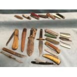 A collection of knives - pen knives, sheath knives, a wood handled folding sawknife, bone handled, a