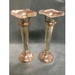A pair of tall silver hallmarked trumpet vases with waved rims on tapering bodies above circular