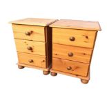 A pair of pine dwarf chests, each with three knobbed drawers, raised on bun feet. (17in x 15.5in x