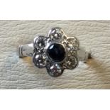 An 18ct white gold sapphire & diamond daisy ring, the bezel set central stone of almost half a