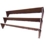 A set of rectangular mahogany wall shelves on angled supports, the platforms with plate grooves. (