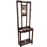 An oak hallstand, the back with rectangular mirror within a frame mounted with six pegs, the base