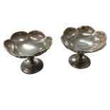 A pair of hallmarked silver bon-bon dishes with pierced scalloped bowls on column stands above