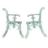 A pair of Victorian cast iron bench ends with scrolled decoration to channelled frames, having