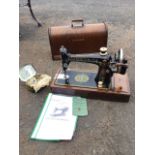 A domed oak cased Singer sewing machine, No 66 with oscillating hook, complete with instruction