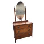A 1950s oak dressing table with oval bevelled mirror on square moulded column supports with turned