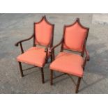 A pair of gothic shaped armchairs with panelled backs and upholstered seats on ring-turned legs