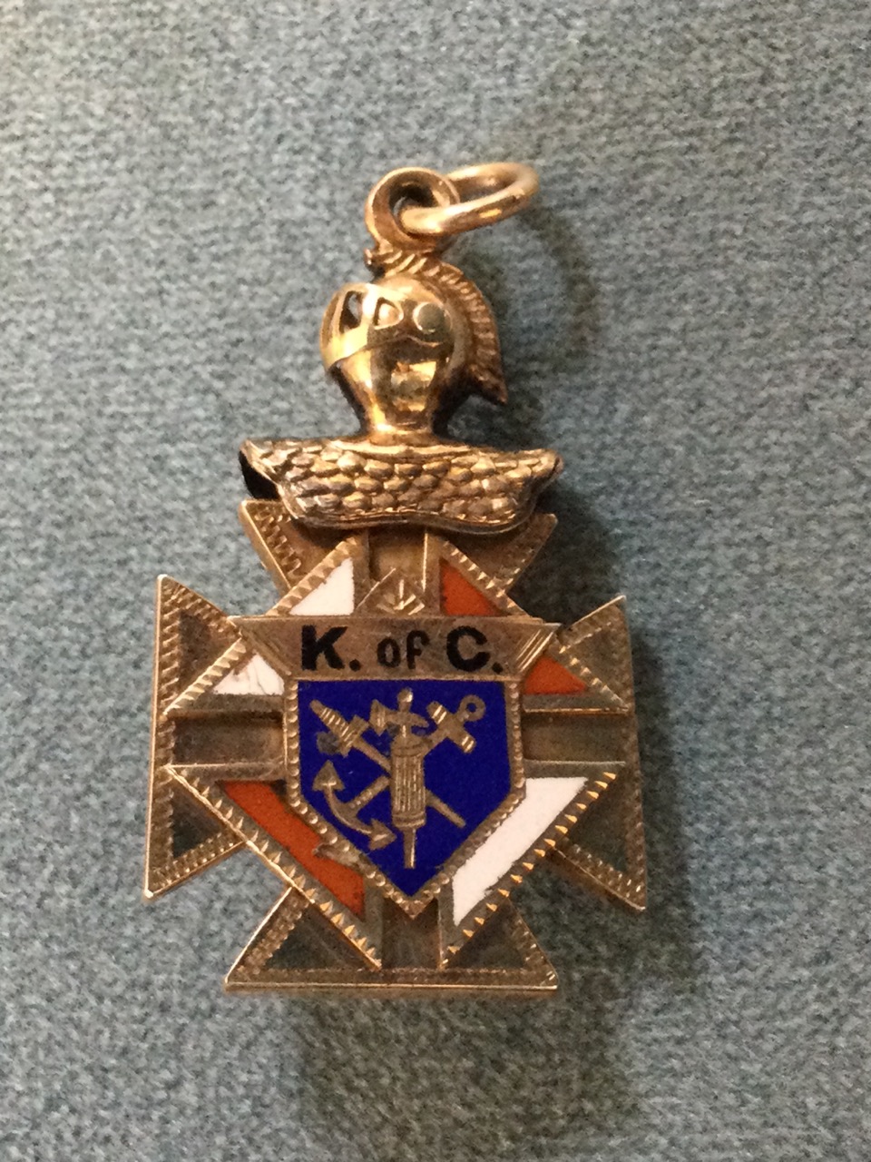 An enamelled gold fob of maltese cross form, one side with applied skull & crossbones with the