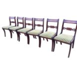 A set of six regency style mahogany dining chairs, having bar backs above pierced scroll-carved