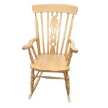 A reproduction beech farmhouse rocking chair, the back with slats framing a pierced fiddle splat,