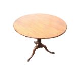 A circular nineteenth century mahogany flip-top occasional table, raised on a fluted tapering column