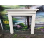 A painted chimneypiece with rectangular moulded mantlepiece above a shaped frieze, the fireplace