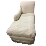A contemporary chaise with shaped padded back and arm above a long loose cushion seat and sprung
