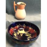A Moorcroft tube lined fruit bowl embossed with fruit on deep blue ground - repaired; and a McIntyre