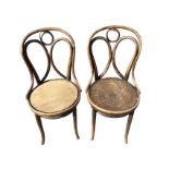 A pair of Thonet bentwood chairs with hooped backs above circular seats raised on turned legs joined