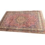A fine Indian rug woven with floral medallion having scalloped borders on red field, overall