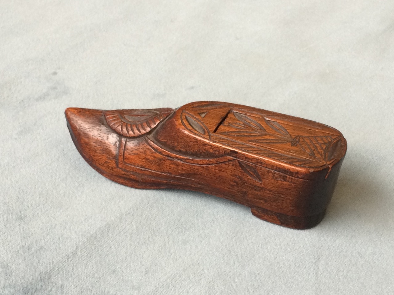 A nineteenth century carved mahogany snuff box in the form of a shoe, the sliding lid with chisel