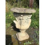 A classical composition stone urn, the body cast with frieze of gambolling putti above a fluted base