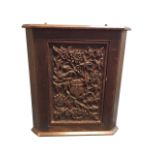 A stained oak corner cabinet with deep floral carving to panelled door on pounced ground. (20in x