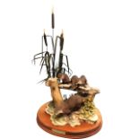 A large Border Fine Arts group of otters mounted on oval mahogany plinth, the 1994 numbered