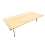 A contemporary rectangular oak dining table with cleated plank top on triangular tapering brass
