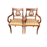 A pair of regency style armchairs with tablet backs inlaid with brass stringing above carved