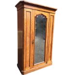 A Victorian satinwood wardrobe with canted corners, the moulded cornice above a central mirror