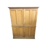 A large Victorian scumbled pine linen cupboard with moulded ogee cornice above four twin panelled