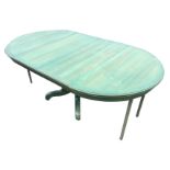 A stained reproduction extending dining table, the circular moulded top with spare leaves, raised on