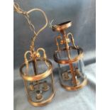 A pair of contemporary brushed brass hall lanterns, with tubular glass shades enclosing three