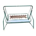 A swinging garden seat, the bench with loose cushion and sprung seat on tubular frame. (83in)