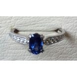 A sapphire & diamond platinum ring, the oval claw set sapphire of just under a full carat, having