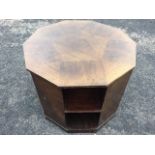 An octagonal walnut coffee table with geometric veneers, the sides with three open shelves, raised