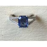 An 18ct white gold sapphire and diamond ring, the rectangular claw set unheated Ceylon sapphire