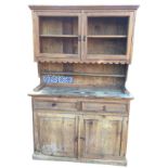 A pine kitchen dresser, the top with formerly glazed doors above a scalloped apron and shelf, the