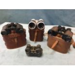 Three leather cased pairs of binoculars; and leather cased set of Edwardian opera glasses. (4)