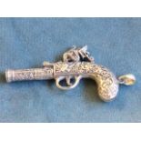 A novelty sterling silver whistle modelled as a flintlock pistol with foliate scrolled decoration,