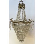 A glass crystal chandelier surmounted by a ring of brass cherubs on chain with swagged ropes above a