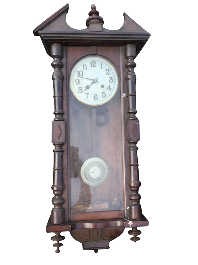 A stained Vienna wallclock with broken pediment framing a turned finial, above an arched door