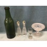 A large antique olive glass wine bottle with band to rim; a pair of cut glass octagonal