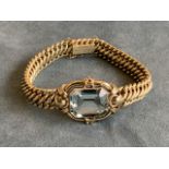 A 14ct gold bracelet, the chain links mounted with rectangular rounded tube frame holding a baguette