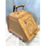 A late Victorian brass scuttle raised on bun feet, with embossed panel to angled hinged lid,