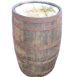 An oak whiskey barrel, the staves bound by six riveted metal strap bands. (35in)