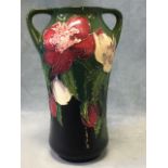 A tube lined Moorcroft vase with art nouveau style handles to shoulders, decorated with fruit &