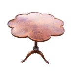 A scalloped top elm occasional table, supported on a turned column with tripartite legs & pad