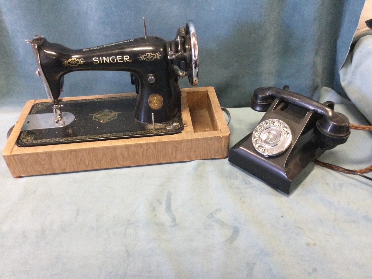 A Singer electric cast iron sewing machine, mounted on later drawer stand; and an old black bakelite