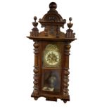A Victorian walnut Vienna wallclock with arched carved crest flanked by turned finials having