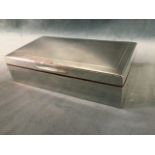 A rectangular hallmarked silver cigarette box with engine turned decoration to lid, having cedar