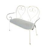 A metal bench with scrolled heart shaped motifs to shaped back, the rectangular rounded seat on