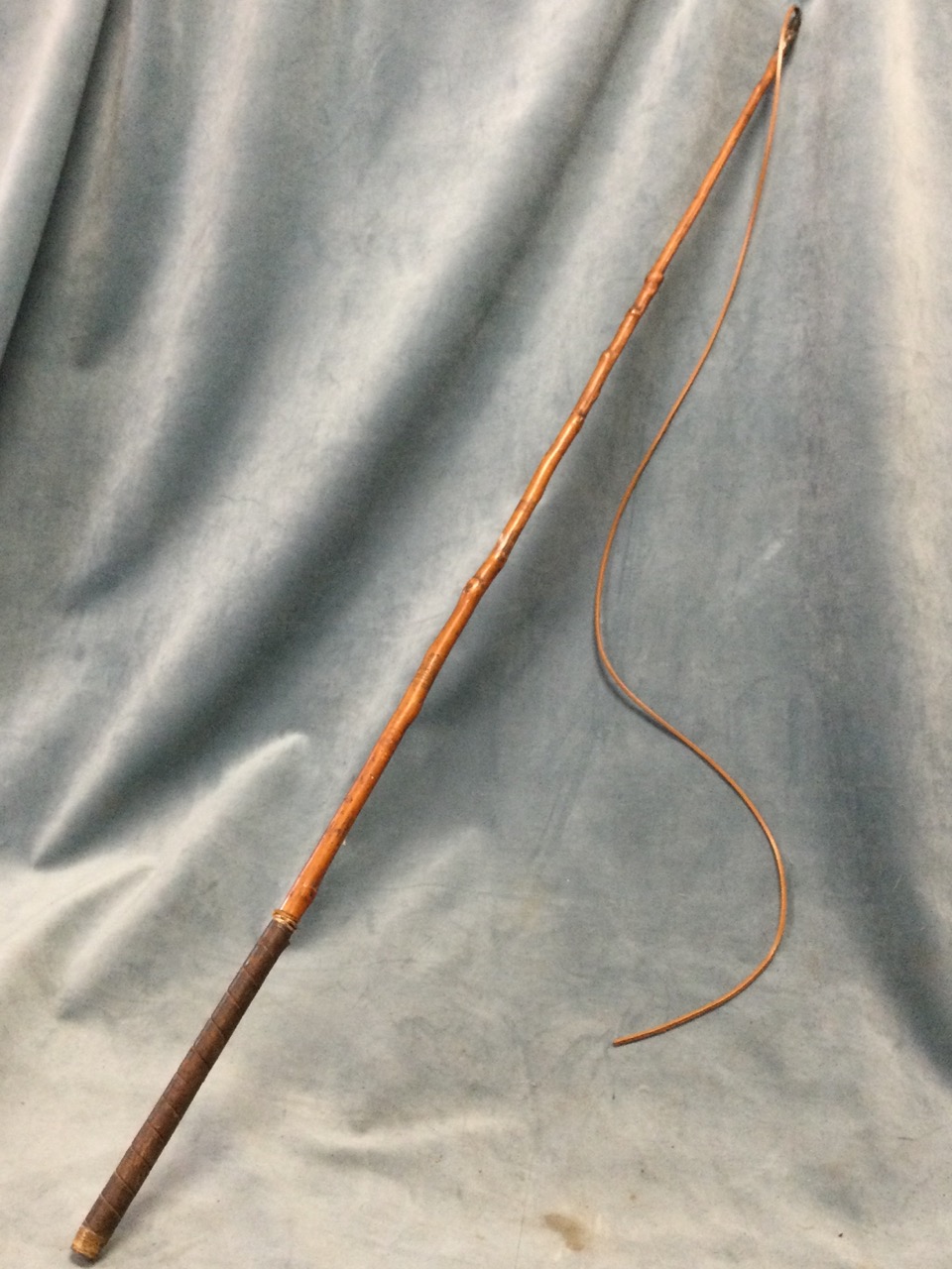 A George Schomber coachmans whip with leather thong and tapering cane shaft bound with leather